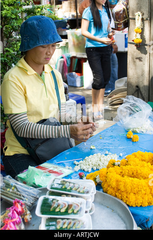 Un vendeur de rue de fleurs dans une rue de Bangkok organise des fleurs à vendre Banque D'Images