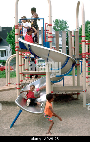 L'âge de 5 et 7 ans d'amis jouant sur la diapositive en aire de jeux. Minneapolis Minnesota USA Banque D'Images