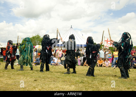 Bedlam Morris Dancers en noir robes Rag lutte danse avec des bâtons en style païennes traditionnelles Tewkesbury Fête médiévale l'Angleterre Banque D'Images