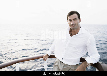 Portrait of a Mid adult man appuyé contre la rambarde du bateau Banque D'Images