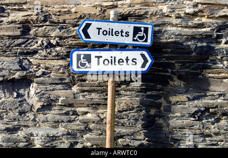 Des informations contradictoires sur une plaque de rue pour toilettes pour handicapés Banque D'Images