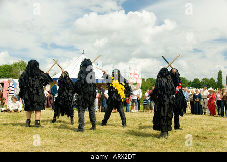 Bedlam Morris Dancers en noir robes Rag lutte danse avec des bâtons en style païennes traditionnelles Tewkesbury Fête médiévale l'Angleterre Banque D'Images