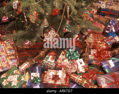 Des cadeaux de Noël éparpillés autour de la base d'un vrai arbre de Noël dans le salon intérieur Banque D'Images
