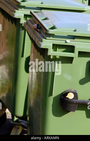 Les bacs de couleur verte wheelie recyclin conteneurs munis de couvercles alignés rangées de l'extérieur d'un local commercial Banque D'Images