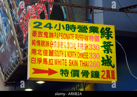 Un rare panneau en anglais à l'extérieur d'une maison close de Mongkok publicité différentes nationalités des femmes disponible à Hong Kong Banque D'Images