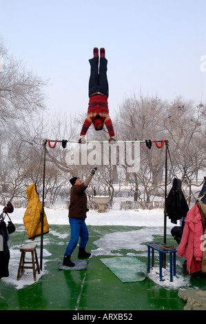 Un chinois d'âge moyen femme gymnastique matinale dans le parc Staline Harbin en Chine l'hiver 2005 Banque D'Images