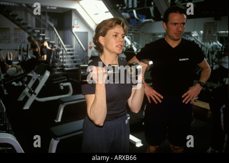 Femme qui garde la forme dans une salle de gym Keep Fit avec Londres Angleterre années 2000 HOMER SYKES Banque D'Images