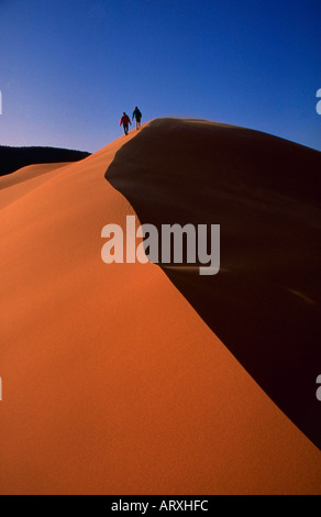 Les Randonneurs marchant le long de crête de dune de sable de Coral Pink Sand Dunes State Park dans l'Utah du sud Banque D'Images