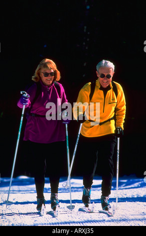 Man and Woman ski sur une journée ensoleillée dans la neige Banque D'Images