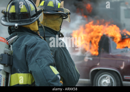 Deux soldats du feu sont un feu de voiture Banque D'Images