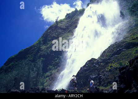 Les visiteurs obtiennent un regard étroit à Kaluahina Falls, accessible depuis la Waipio plage de sable noir. Banque D'Images