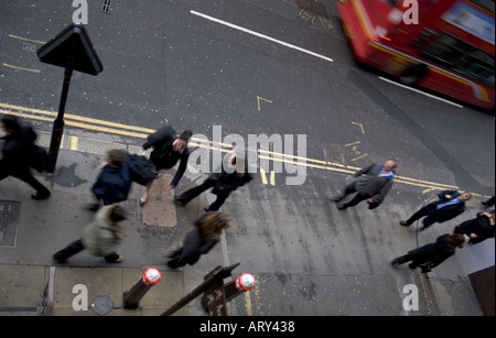 Les navetteurs et les piétons traversent la rue animée London Wall dans la City de Londres avec un bus mobile en arrière-plan pendant les heures de pointe du matin Banque D'Images