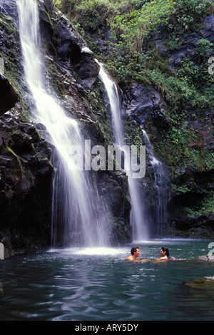 Jeune couple nager près d'une chute sur la route de Hana, Maui. Banque D'Images