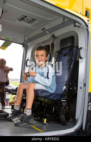 Petit garçon assis dans le siège de l'hélicoptère de police et d'ambulance d'air Banque D'Images