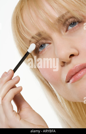 Woman applying eye shadow Banque D'Images