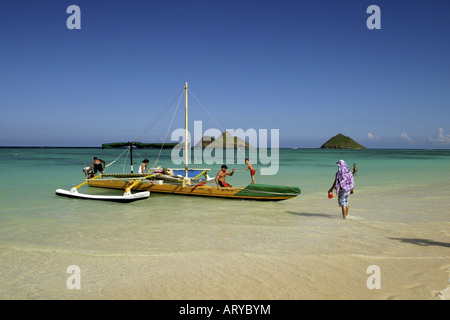 Pirogue repose doucement sur les sables de plage Lanikai invitant. La pittoresque Lua Moku îles dans l'arrière-plan. Windward Oahu. Banque D'Images