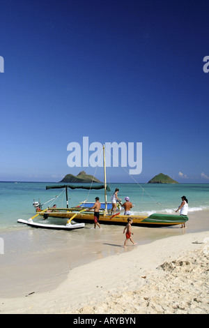 Pirogue repose doucement sur les sables de plage Lanikai invitant. La pittoresque Lua Moku îles dans l'arrière-plan. Windward Oahu. Banque D'Images