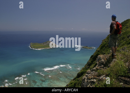 Randonneur (man) s'arrête pour profiter d'une vue panoramique de l'île de lapin(Manana) Kaohikaipu,island(Blackrock)et Kaupo Bay(cafard Bay) Banque D'Images