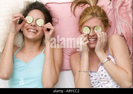 Les filles avec les concombres sur les yeux Banque D'Images