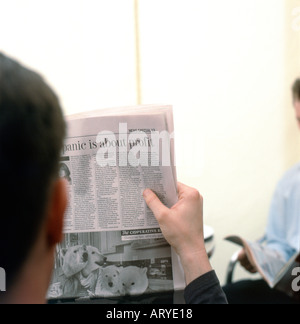 Vue arrière d'un homme lisant le journal The Guardian Banque D'Images