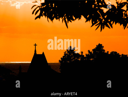 Or spectaculaire coucher de soleil sur l'église et arbres en silhouette à la Réunion Banque D'Images