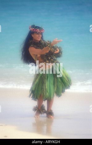 Danseuse de hula en jupe de feuilles de ti sur une plage de sable blanc Banque D'Images