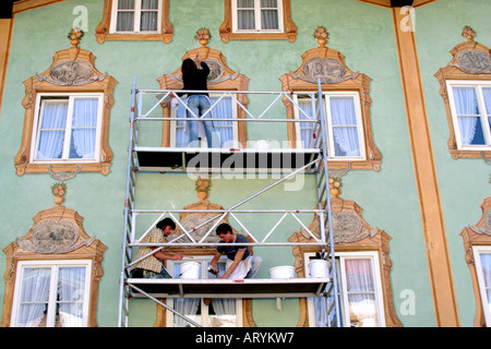 Groupe d'hommes femme restaurateur au travail sur la peinture de façade traditionnelle en Lueftlmalerei Allemagne Bavière Bad Tolz Banque D'Images