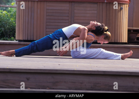 Le Hatha yoga accompli à l'arrière double position extensible par deux femmes Banque D'Images