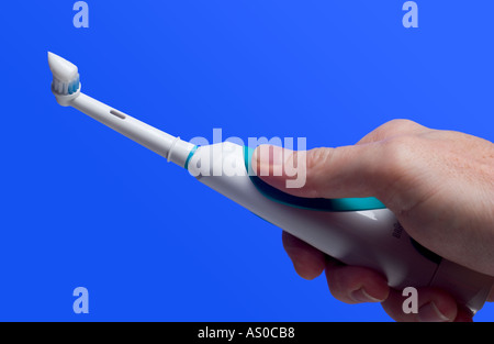 brosse à dents électrique avec dentifrice. Gros plan d'une main de homme tenant la brosse à dents électrique. Banque D'Images