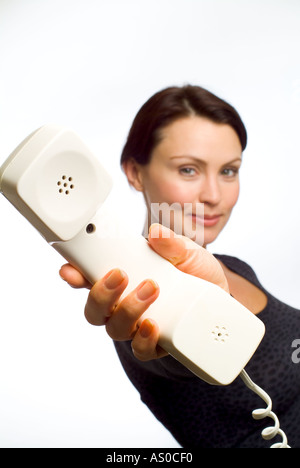 Femme passant le téléphone à quelqu'un Banque D'Images
