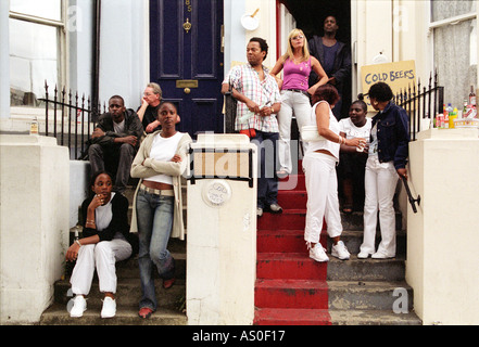 Groupe de jeunes de différentes races chat sur la porte à Londres pendant la festival de Notting Hill. Banque D'Images