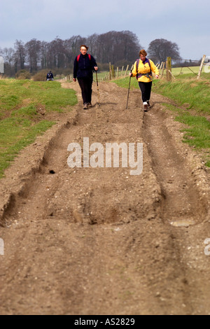 Deux Randonneurs marchant dans les ornières faites par les véhicules 4x4 sur le sentier national Ridgeway byway dans Berkshire England UK Banque D'Images