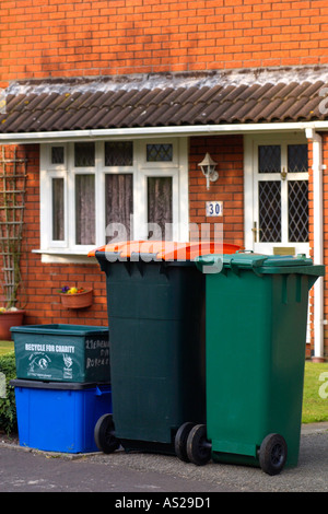 Caisses remplies de matériau de recyclage et wheelie bacs pleins d'ordures domestiques à l'enfouissement et le compostage à l'extérieur de maisons UK Banque D'Images