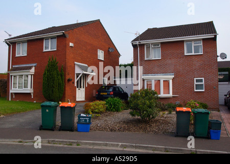 Caisses remplies de matériau de recyclage et wheelie bacs pleins d'ordures domestiques à l'enfouissement et le compostage à l'extérieur de maisons UK Banque D'Images