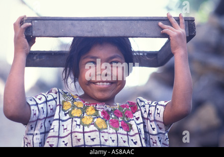 Friendly fille dans le costume tribal distinctif de son Tzutihil communauté Maya Santiago Atitlan Guatemala Banque D'Images