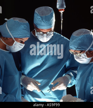 Le chirurgien et deux assistants performing surgery Banque D'Images