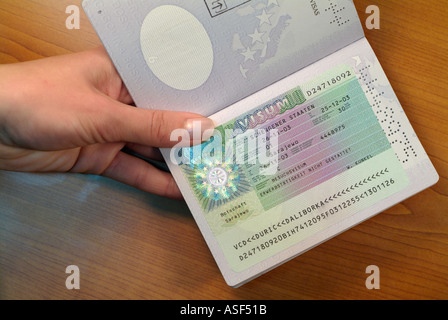 Femme de l'Europe de l'est passant sur un passeport avec un visa allemand sur la page, Close Up. Banque D'Images
