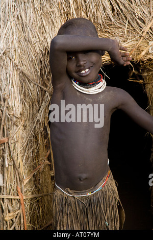 Smiling Girl du Nyantaom tribu à sa hutte, vallée de la rivière Omo, en Ethiopie Banque D'Images