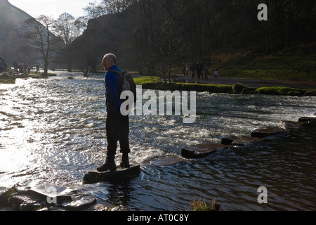 Walker sur le Stepping Stones, Dovedale, parc national de Peak District, Derbyshire, Royaume-Uni Banque D'Images