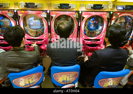 Joueurs dans un salon de pachinko de Tokyo au Japon Banque D'Images