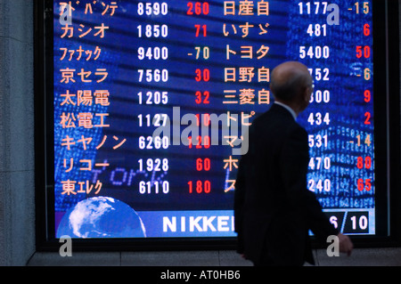 Homme marche indice boursier passé sur Tokyo Japon Street Banque D'Images
