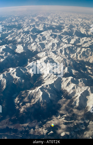 Grand angle vertical de les sommets enneigés de la chaîne de montagnes des Alpes à partir de la fenêtre d'un avion Banque D'Images