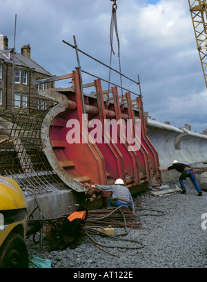 Positionnement des ouvriers pour coffrage en acier pendant la construction d'un mur en béton, onde newbiggin-by-the-Sea, Northumberland, England Banque D'Images