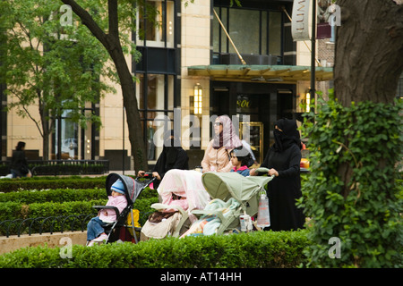 Chicago Illinois attentif trois femmes musulmanes poussant les poussettes dans l'eau Tower Park portant la burqa et voile Banque D'Images