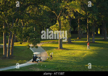 Aurora ILLINOIS mâle adulte golfeur sur Phillips Park Golf Course man swinging golf club panier garé sur le chemin Banque D'Images