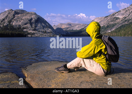 Un randonneur se détend sur la rive du Lac Tenaya Tuolumne Meadows, près de Yosemite National Park, California, USA Banque D'Images