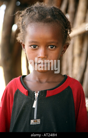 Jeune fille africaine de mouches sur son visage par sa maison Banque D'Images