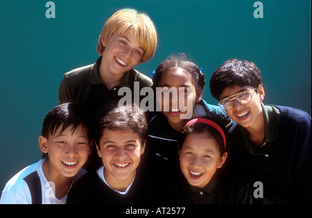 Groupe multiracial of junior school les enfants à l'extérieur du campus dans la ville ensoleillée de jeux pour enfants Banque D'Images