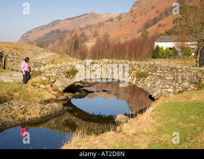 Pont sur watendlath frosty lumineux matin de printemps dans la région de Lake District National Park Cumbria UK avec rambler Banque D'Images