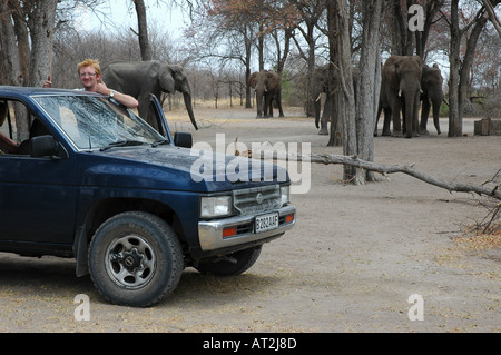 L'homme avec les éléphants et quatre roues motrices au camp site Nxai Pan National Park désert du Kalahari Botswana Afrique du Sud Banque D'Images